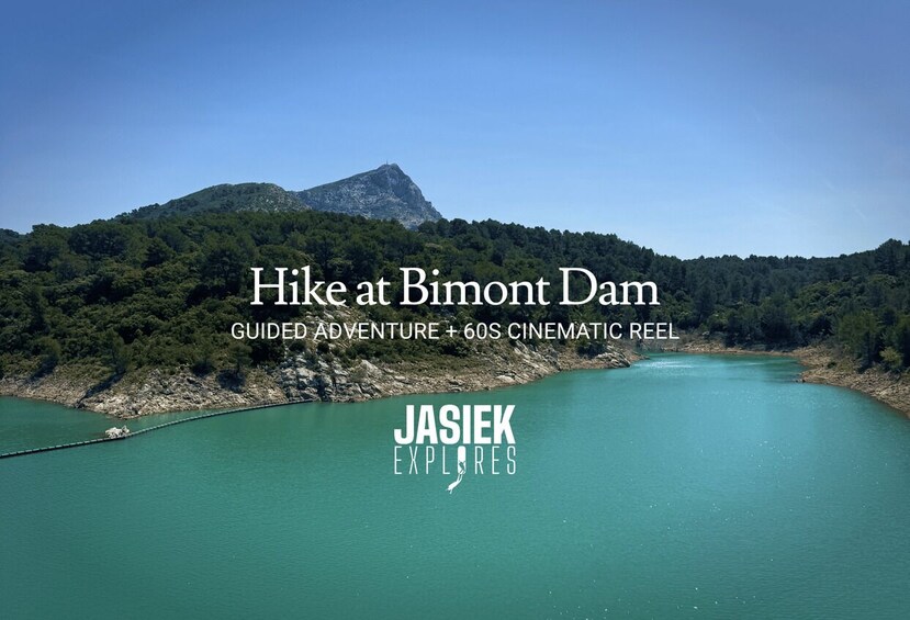 A hilly landscape with a body of water and a dam. 1
