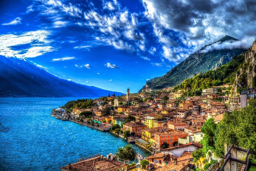 A coastal town with a mountain backdrop, a body of water, and a prominent tower. 2