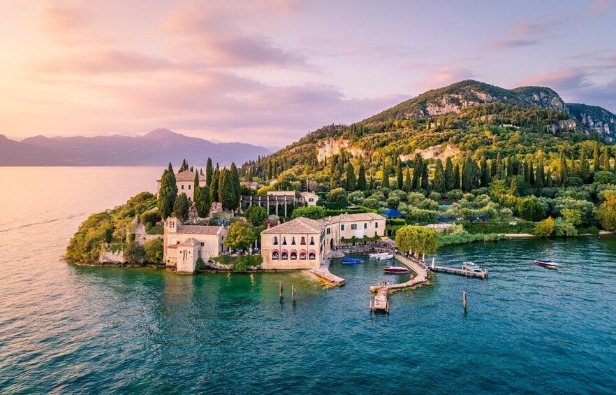 A coastal town with historic buildings, a marina, and a backdrop of mountains. 5