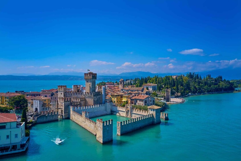 A coastal town with historic fortifications, a tower, and a clear blue sea. 4
