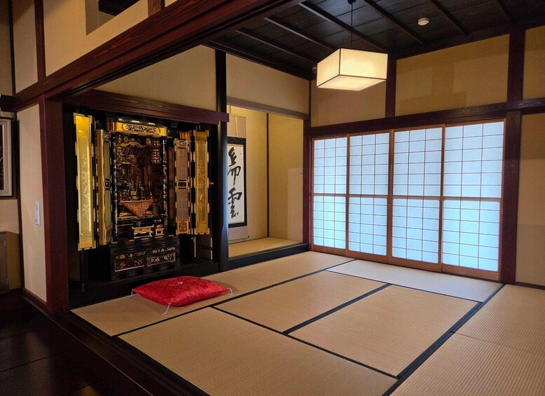 A traditional Japanese room with tatami flooring, a shoji screen, and a decorative alcove with calligraphy. 3