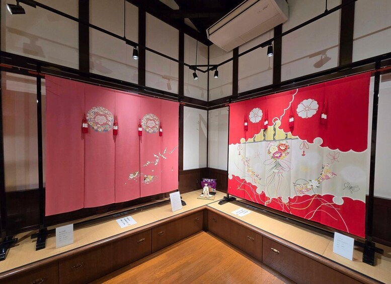 A traditional Japanese room with tatami flooring, red sliding doors with floral designs, and a display case with a purple object. 2