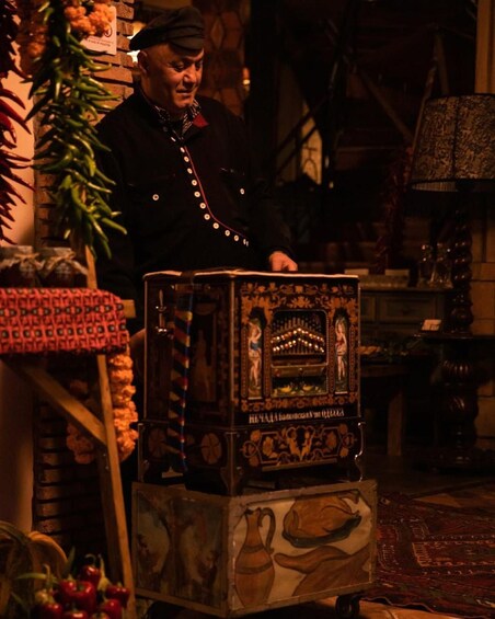 A person standing behind a decorative cabinet with intricate designs and a sign with text. 3