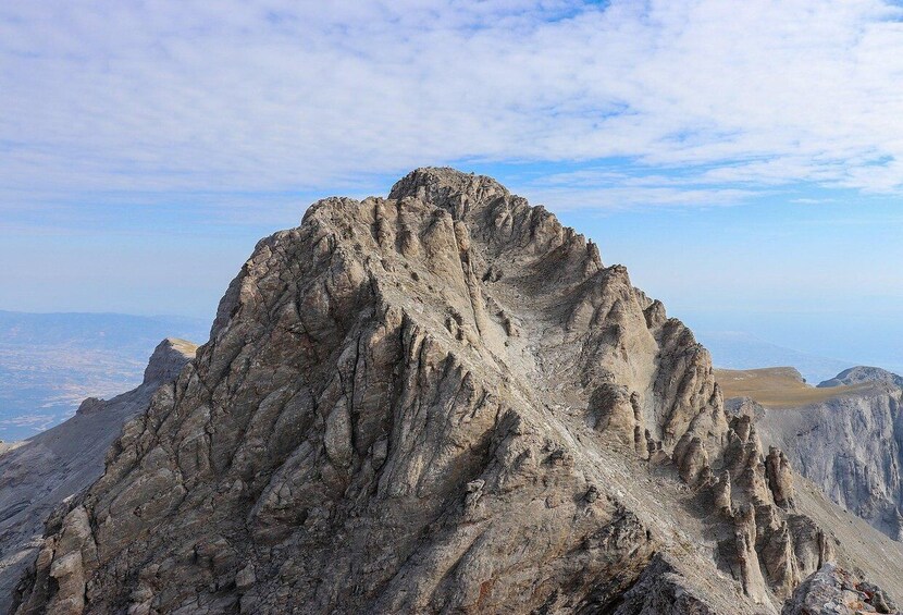 A rugged mountain peak with sharp ridges and a clear sky. 5