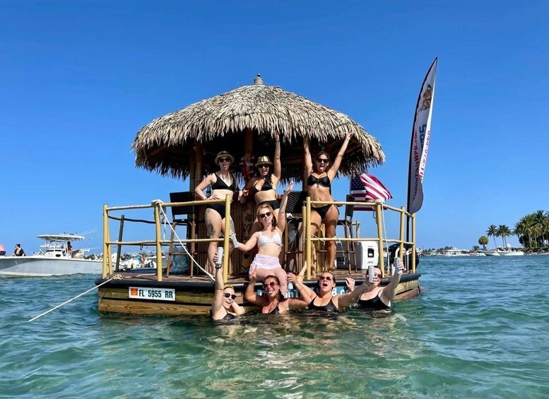 A boat with a thatched roof, passengers in swimwear, and a clear blue sky. 1