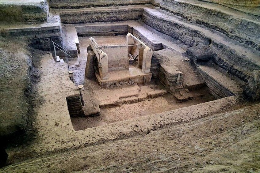 An archaeological site with terraced structures and a central stone platform. 3