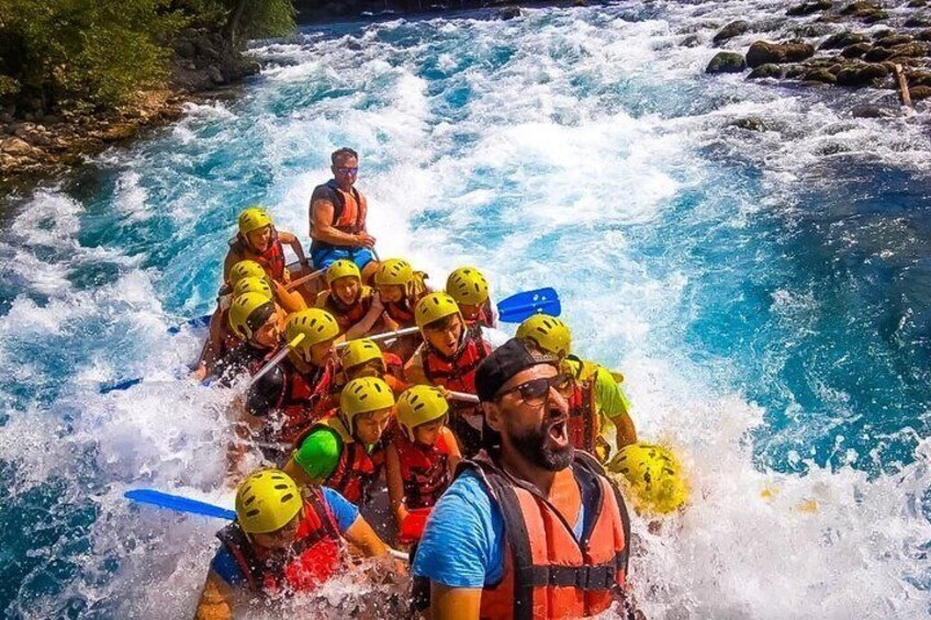 A group of people in a raft navigating a river with rapids. 4