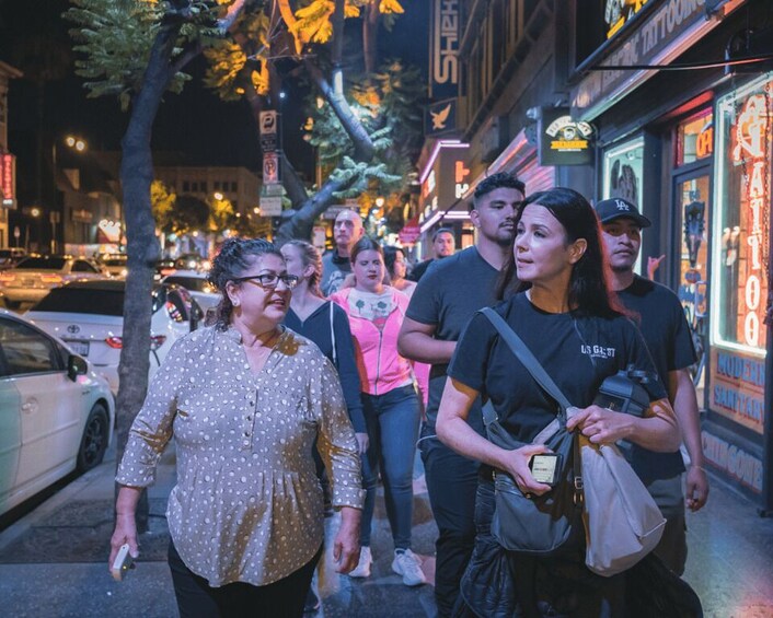 A group of people walking on a city street at night. 4