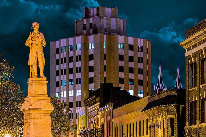 A nighttime cityscape with a prominent statue, illuminated buildings, and distinctive spires. 2