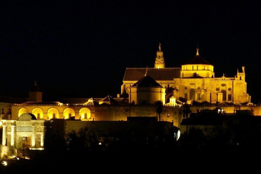 A historic building with arches and domes, illuminated at night. 1