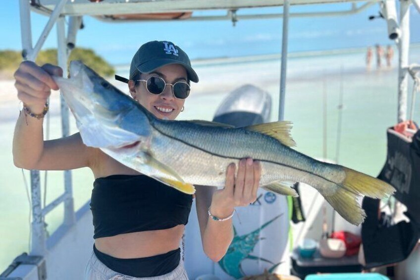 A person holding a fish on a boat. 5