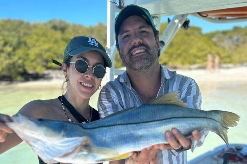 Two people holding a fish. 4