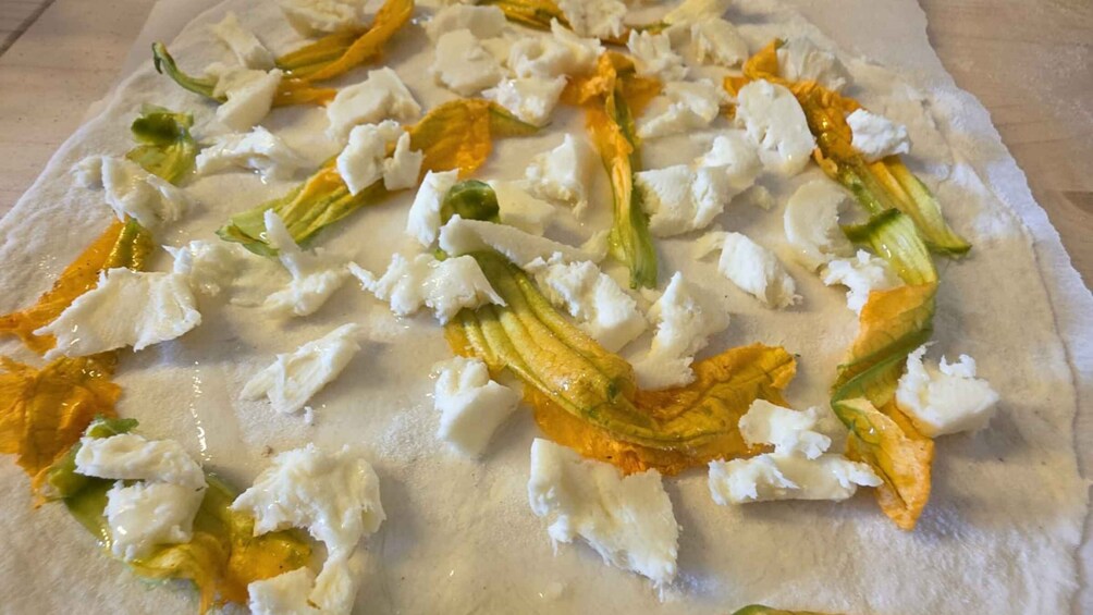 A flatbread with feta cheese and green vegetables. 5