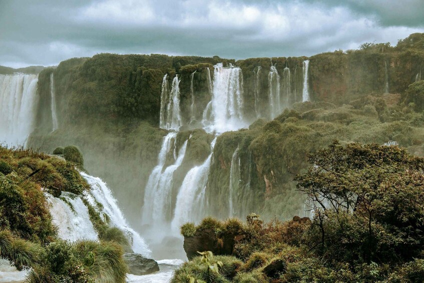 A multi-tiered waterfall surrounded by dense vegetation. 2
