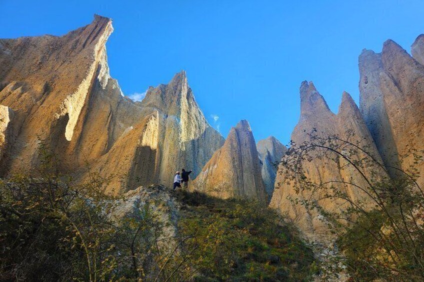 A mountainous landscape with sharp peaks and a hiker in the foreground. 2