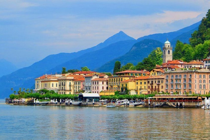 A lakeside town with colorful buildings, a boat dock, and mountains in the background. 5