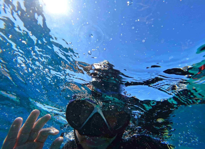 An underwater scene with a person wearing a snorkel and mask, surrounded by bubbles and clear water. 2