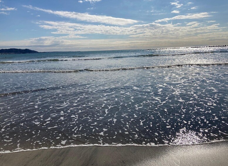 A beach with gentle waves and a clear sky. 4