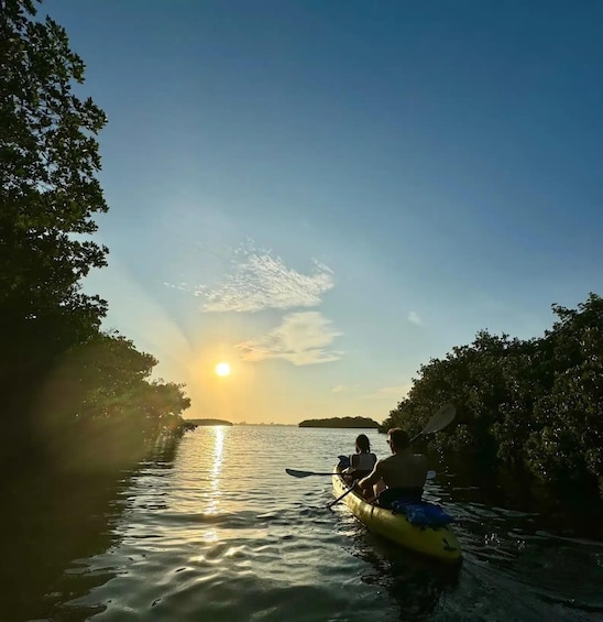 A kayak on a calm river with the sun setting in the background. 3