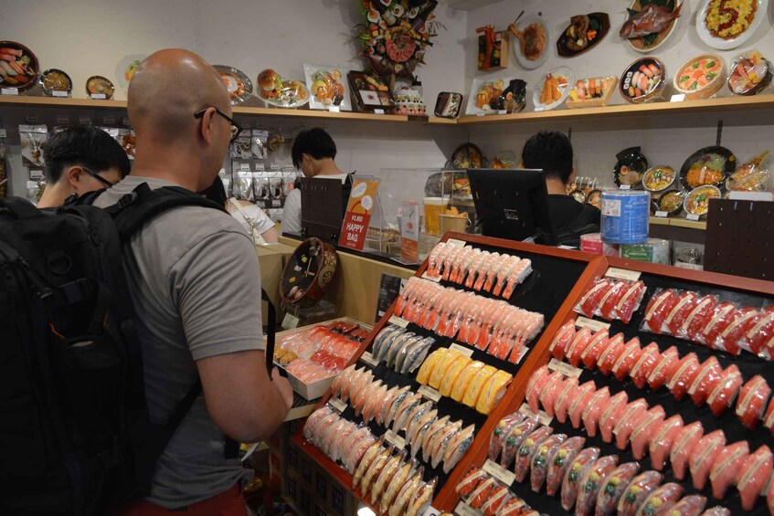 A sushi restaurant with various dishes displayed on shelves and a counter with a sushi display. 1