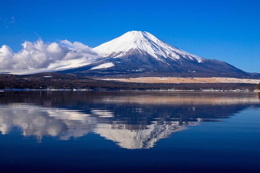 A snow-capped mountain with a clear reflection in calm water. 4
