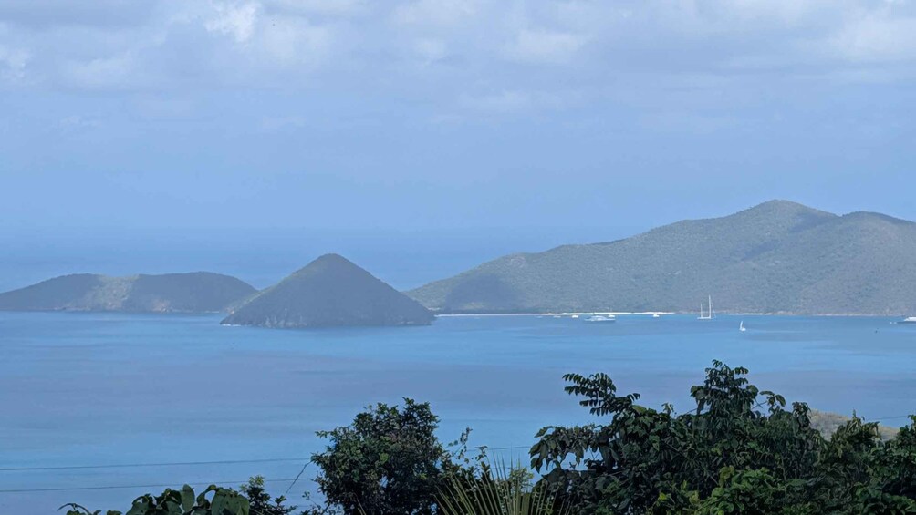 A coastal landscape with several small islands and a sailboat in the distance. 3