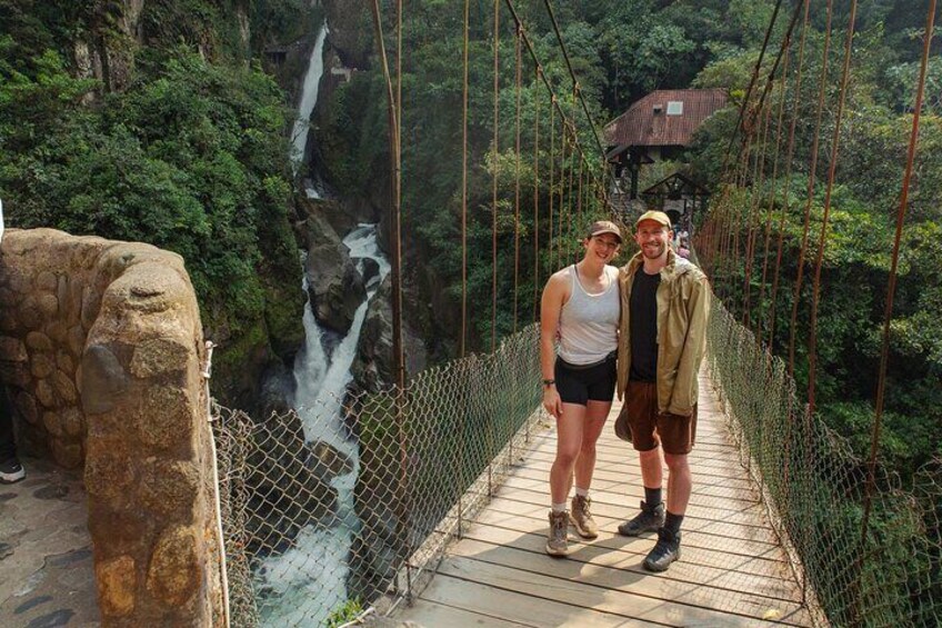 A wooden suspension bridge with a waterfall in the background. 4