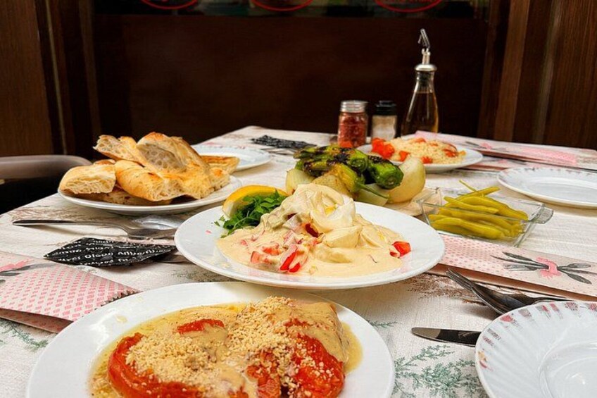 A table with various dishes including pasta, vegetables, and bread. 5