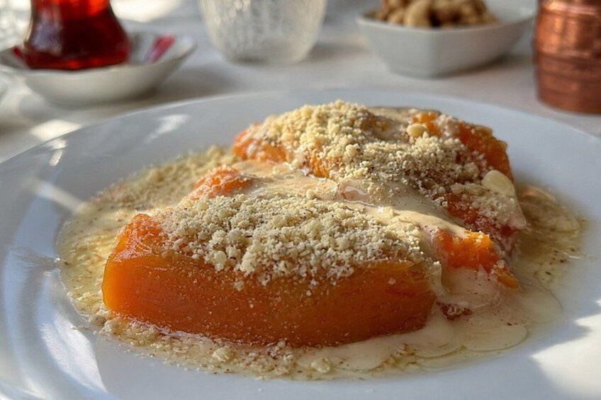 Two pieces of food on a white plate, garnished with crumbs. 4