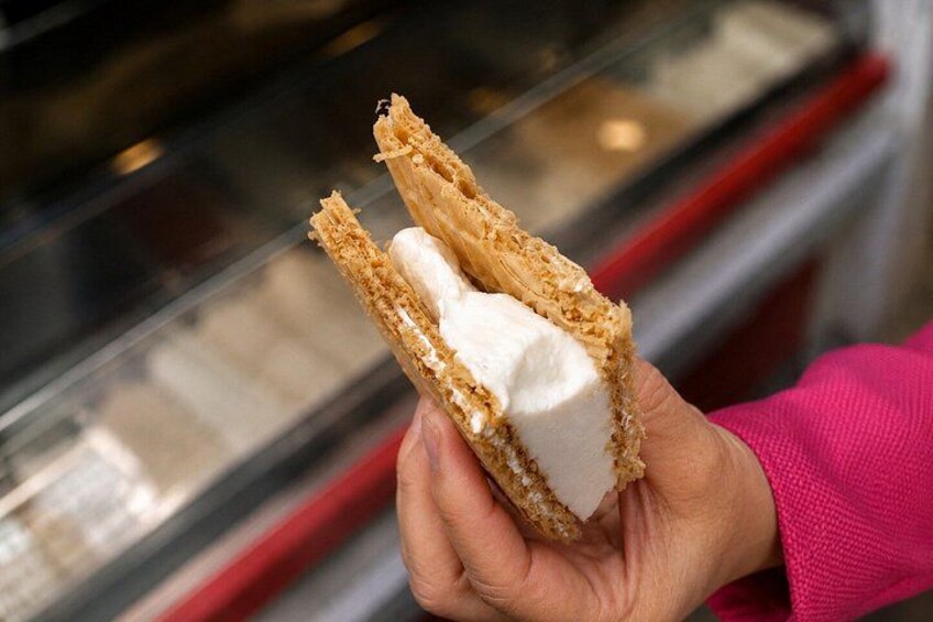 A hand holding a sandwich with a creamy filling. 2