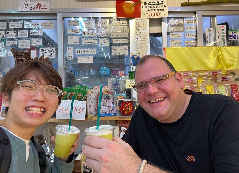 Two people holding drinks with straws in a store with various items on display. 5