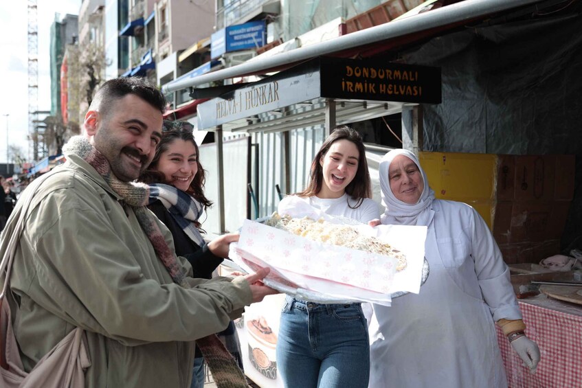 Une scène de rue où une personne tend un objet emballé à un groupe de personnes. 2