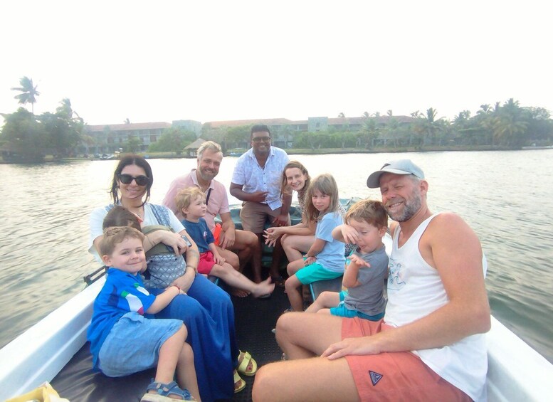 A group of people on a boat on a river with buildings and trees in the background. 3