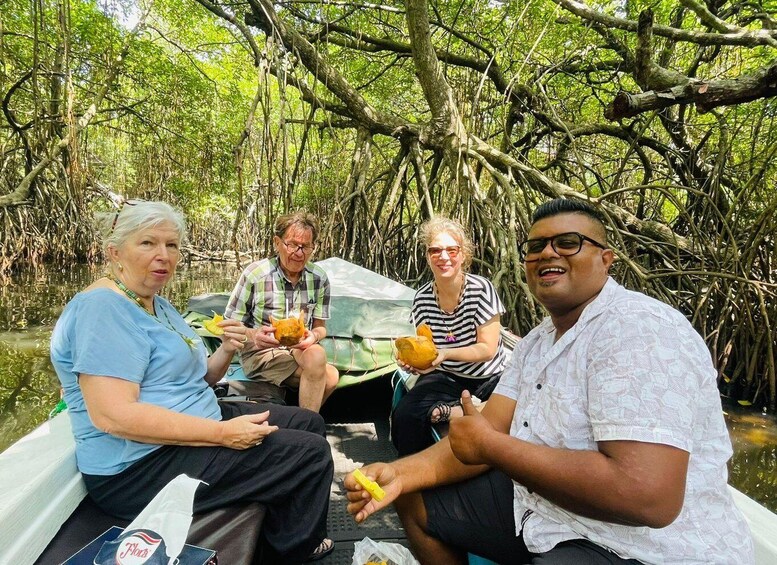 Four people on a boat in a mangrove forest. 1