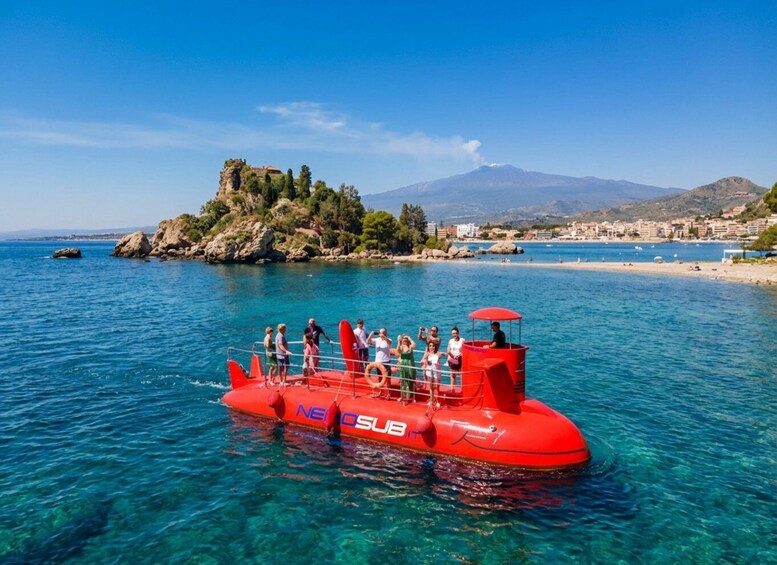 A red submarine with tourists on board near a coastal town. 2