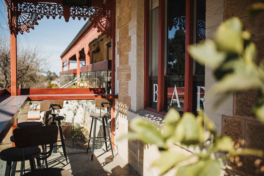 A patio with outdoor seating, a building with a red awning, and a glass door with the word 'BAR' visible. 4
