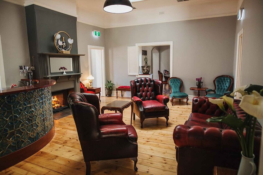 A cozy lounge area with leather chairs, a fireplace, and a bar counter. 5