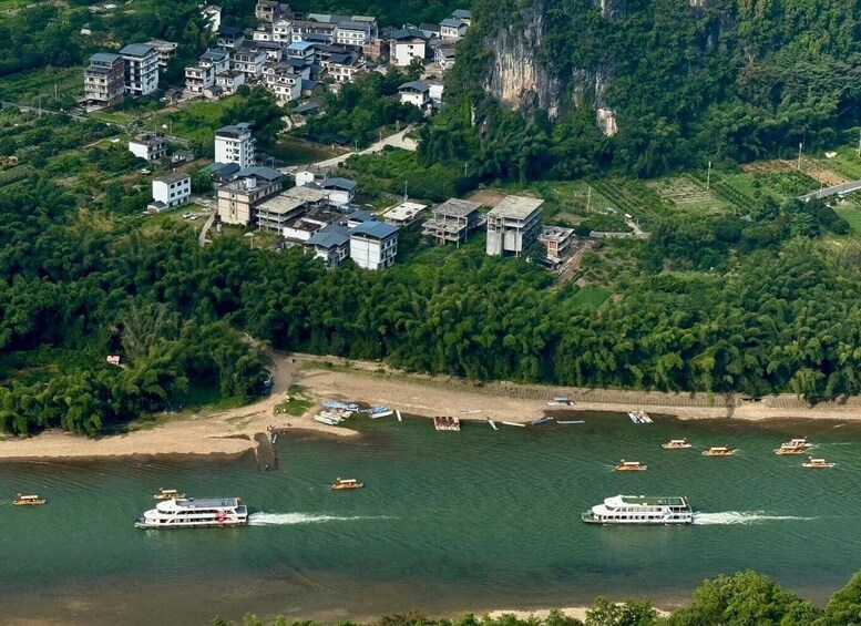 A river with boats, a town with buildings, and a forested hillside. 5