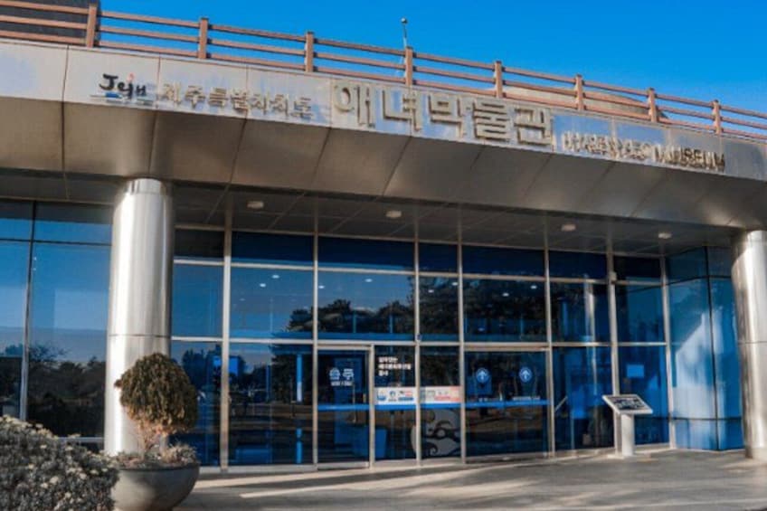 A modern building with large glass windows and a metal roof. 5