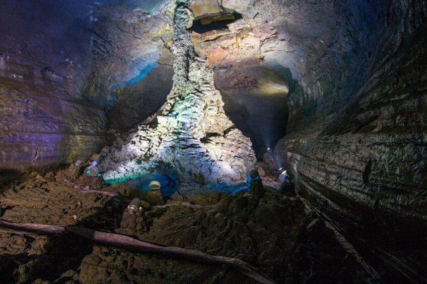 A cave with stalactites and stalagmites, illuminated by artificial lighting. 2