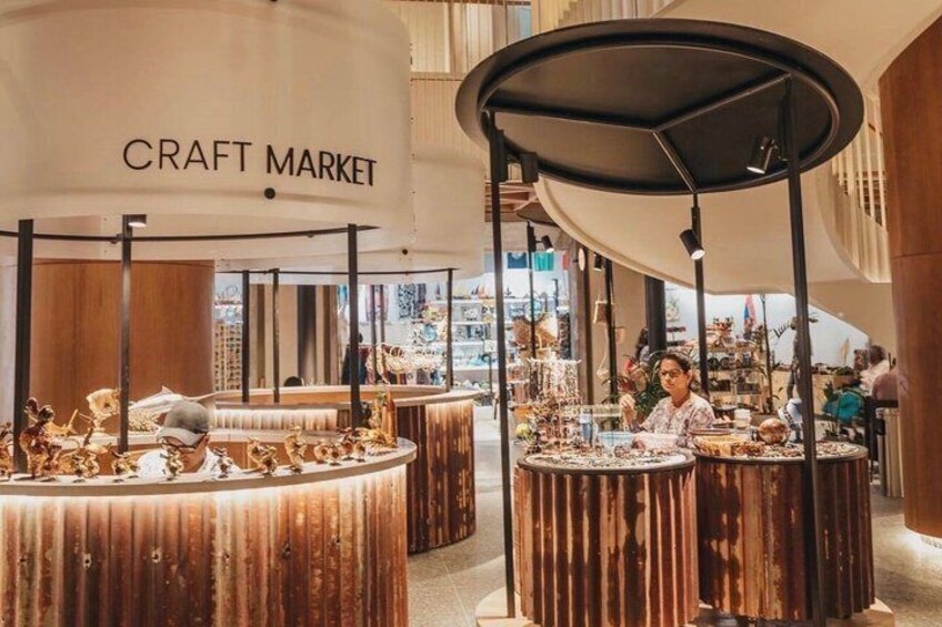 A craft market with wooden display stands and a sign that reads 'CRAFT MARKET.' 2