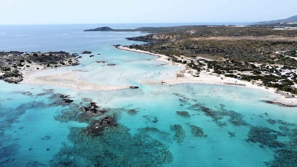 A coastal landscape with clear turquoise waters, sandy beaches, and rocky outcrops. 3