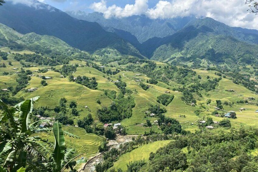 Terraced fields, a river, and mountains in the background. 2