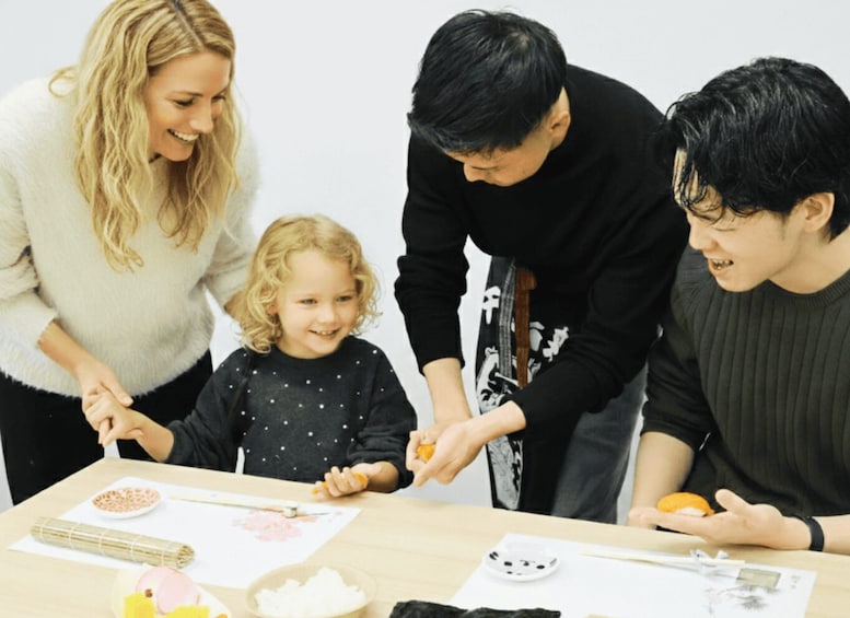 A family engaged in a craft activity at a table with various materials. 3