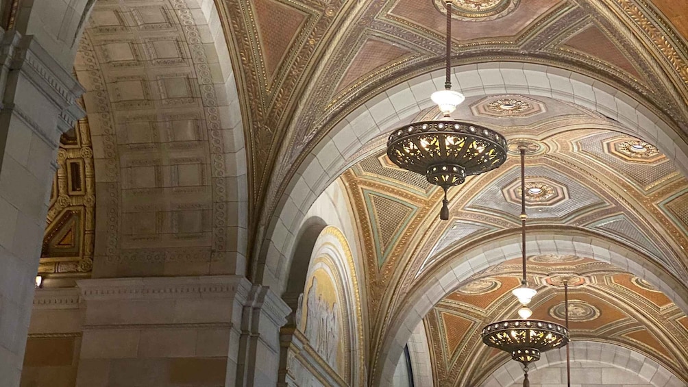 An ornate ceiling with geometric patterns and hanging chandeliers. 5