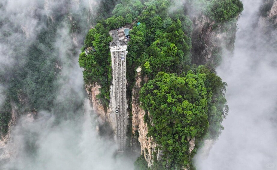 A tower structure amidst lush greenery and misty mountains. 3