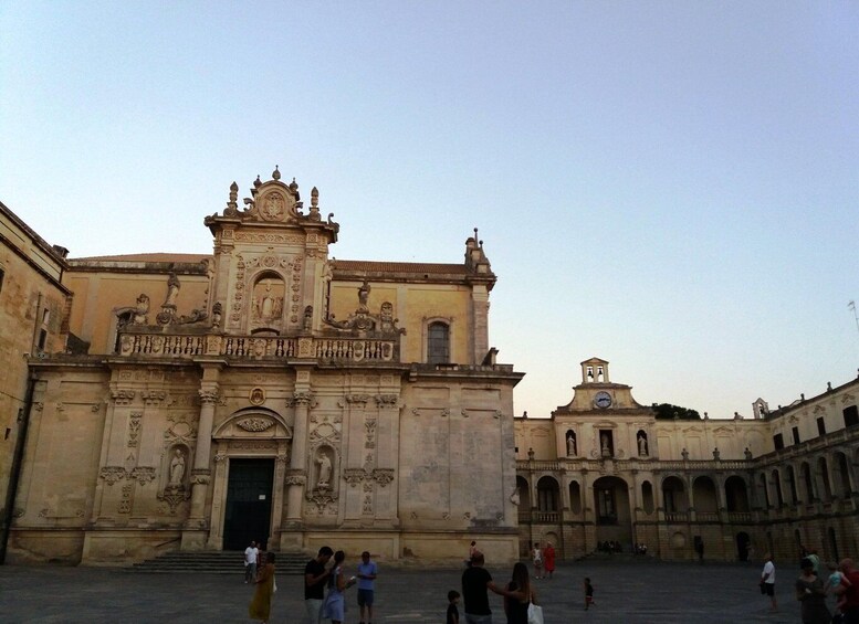 A historic building with ornate architecture, a central doorway, and a clock tower. 4