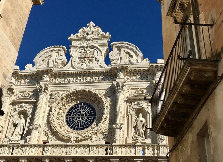 An ornate architectural facade with intricate carvings and a large circular window. 1