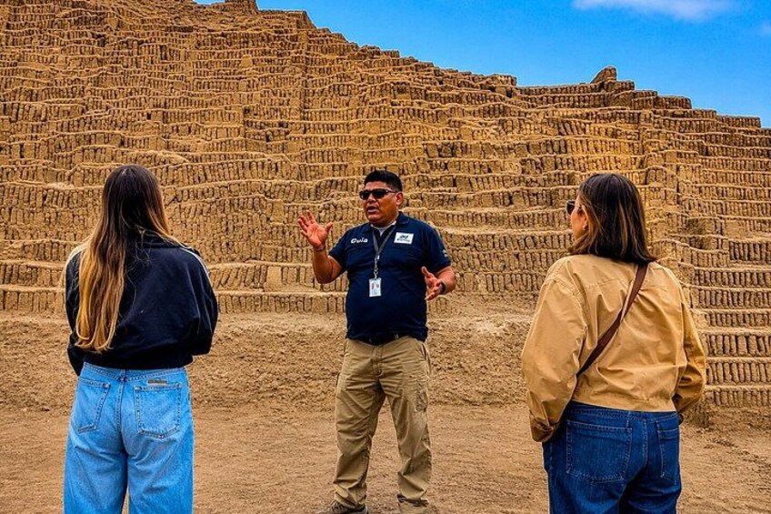 Three people standing in front of a large, terraced structure. 2