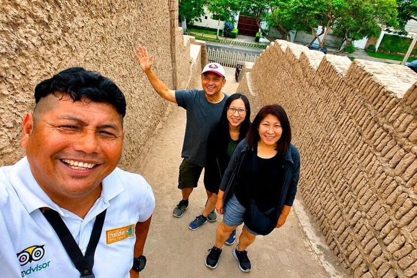 A group of people standing in front of a textured wall. 3